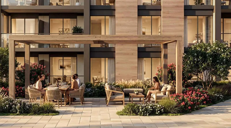 Ground-level terrace at The Woods Abode with a timber pergola, outdoor dining and planting in front of apartment windows