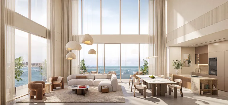 Double-height living room in a duplex at SOMA Residences with full-height glazing onto the sea