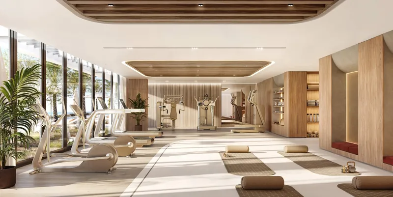 Gymnasium at SOMA Residences with cardio and resistance equipment and full-height glazing onto planting