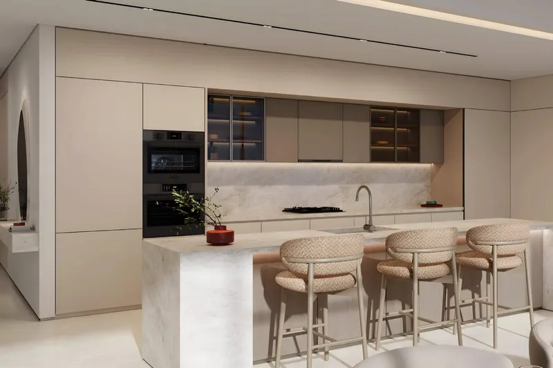 Kitchen at SOMA Residences with a stone island, bar stools and integrated ovens