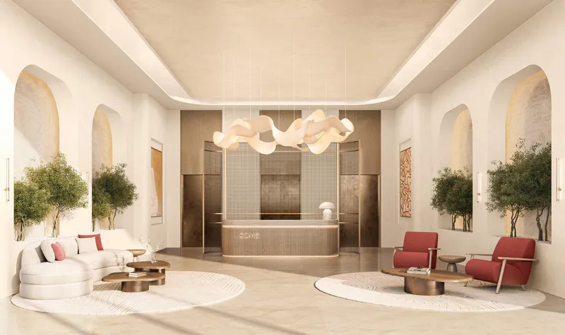 Lobby at SOMA Residences with a reception desk, arched alcoves, planted trees and seating