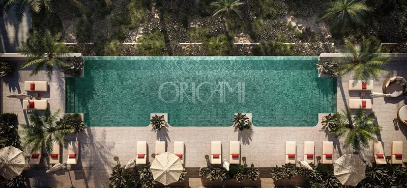 Overhead view of the swimming pool at SOMA Residences with loungers, umbrellas and palms around the deck