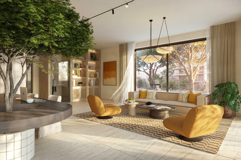 Co-working lounge at The Canopies with an indoor tree, armchairs and large windows onto greenery
