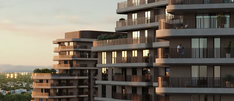 Render of The Wilds Residences buildings at sunset, with curved balconies and planted terraces