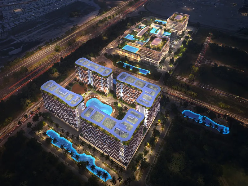 Aerial night render of the Valencia buildings around lit pools, with the rest of DAMAC Lagoons District behind