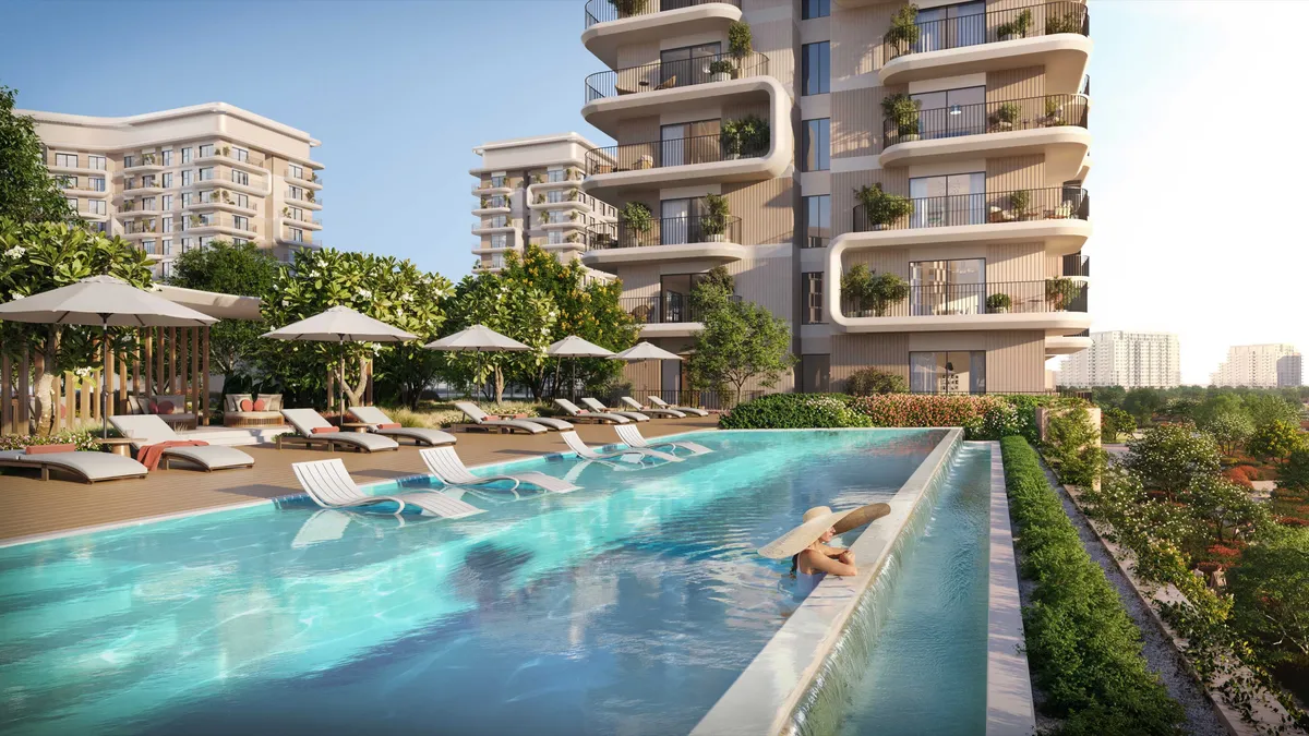 Render of the infinity pool and sun loungers at Yas Park Place beside a mid-rise building with planted balconies