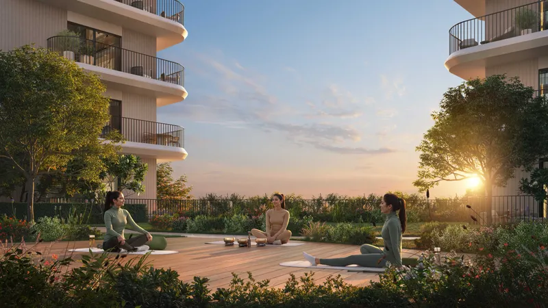 Render of residents doing yoga on a timber deck in the gardens between Yas Park Place buildings at sunset