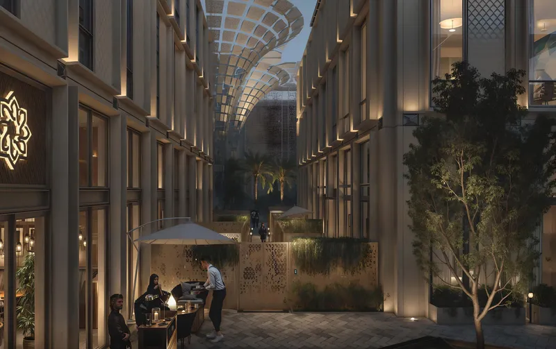 Evening render of a courtyard between Al Waha Residences buildings with a café terrace