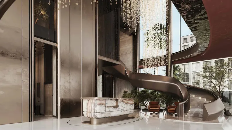 Triple-height lobby with spiral staircase and chandelier at ARYA Residences
