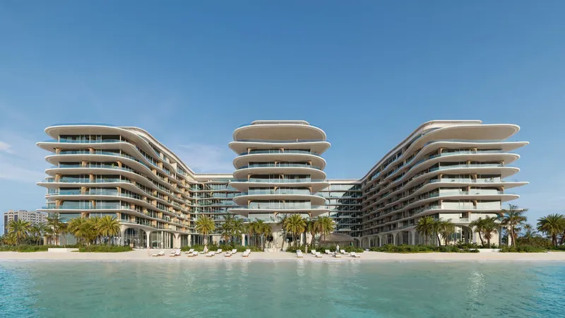 Render of AYA Beachfront Residences seen from the water, with three curved wings behind a sandy beach