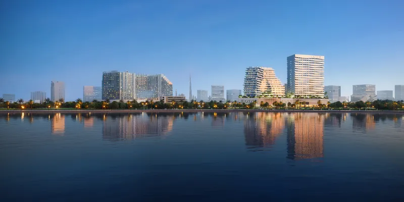 Render of the Creek Views buildings in Dubai Healthcare City seen across Dubai Creek at dusk