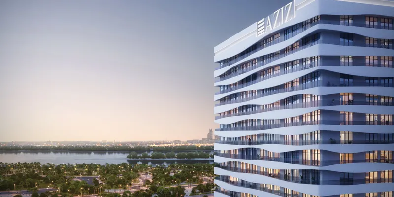 Render of the curved balconies of Creek Views III with Dubai Creek behind at dusk