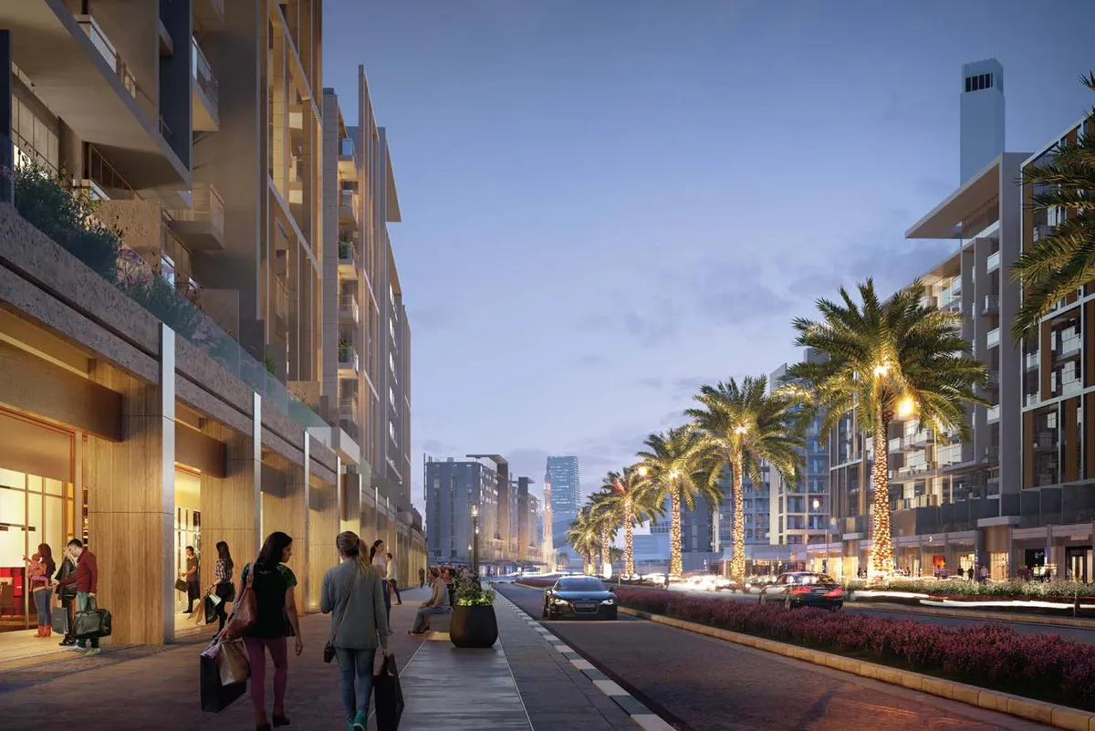 Pedestrian boulevard lined with shops and palm trees at Azizi Riviera