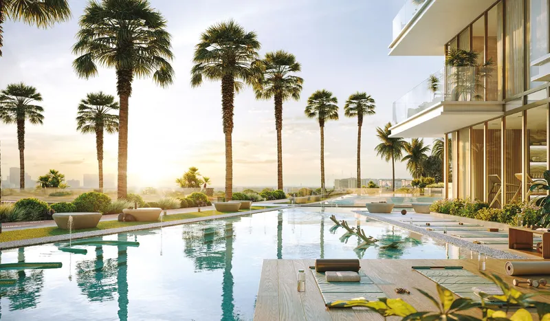 Render of a resort pool with loungers and palm trees beside the towers