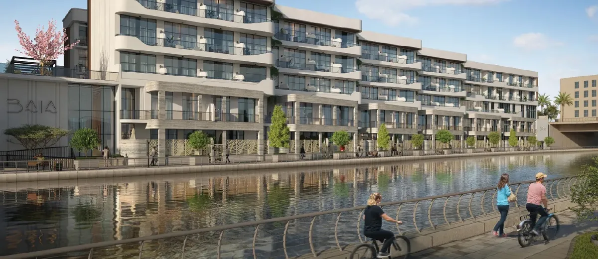 Baia townhouse building on the canal front in Al Raha Beach, Abu Dhabi, with cyclists on the promenade (developer render)