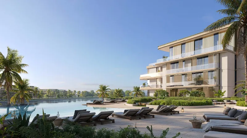 Infinity pool with loungers in front of a Bay Grove Residences building, facing the water