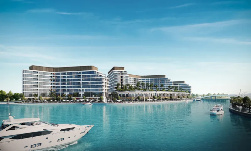 The three buildings of Bayfront Marina Residences on the marina at Sobha Siniya Island, with a yacht in the foreground