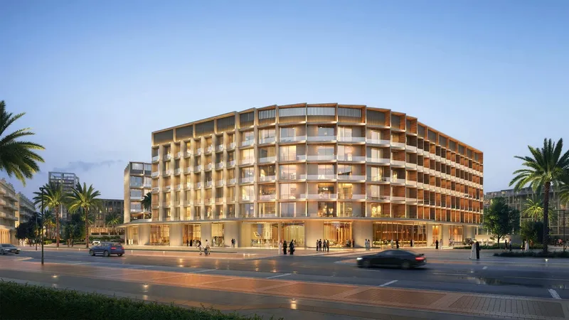 Computer-generated render of Binghatti Hillcrest in Arjan at dusk, a low-rise curved building with shops at street level