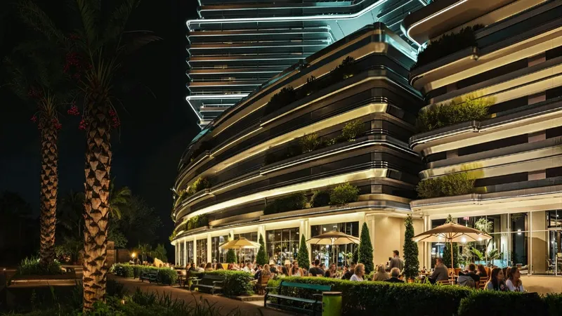 Render of the curved podium of Binghatti Sky Terraces at night, with planted terraces and ground-floor shops and cafes