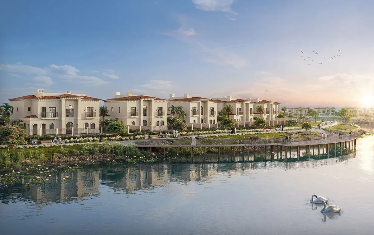 Row of Mediterranean-style Marbella villas behind a boardwalk on the Bloom Living lake