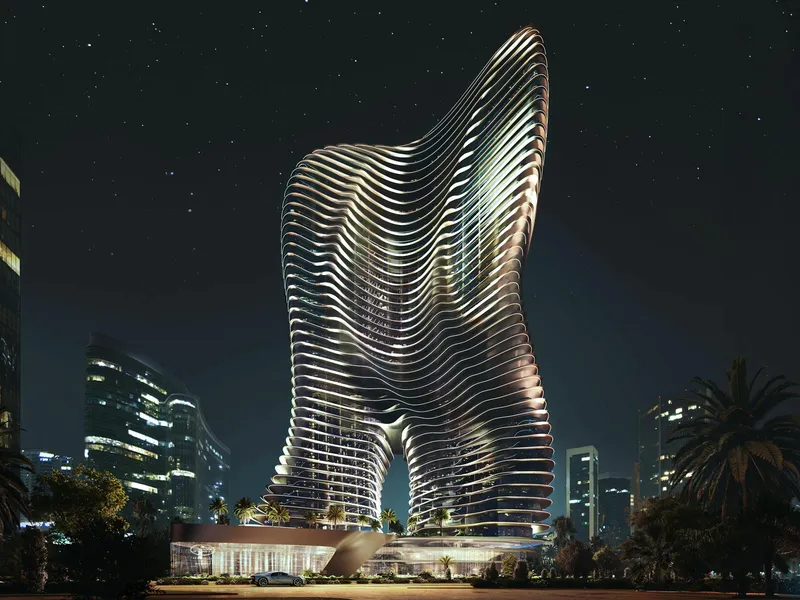 Render of the Bugatti Residences by Binghatti tower lit at night, with its flowing horizontal bands