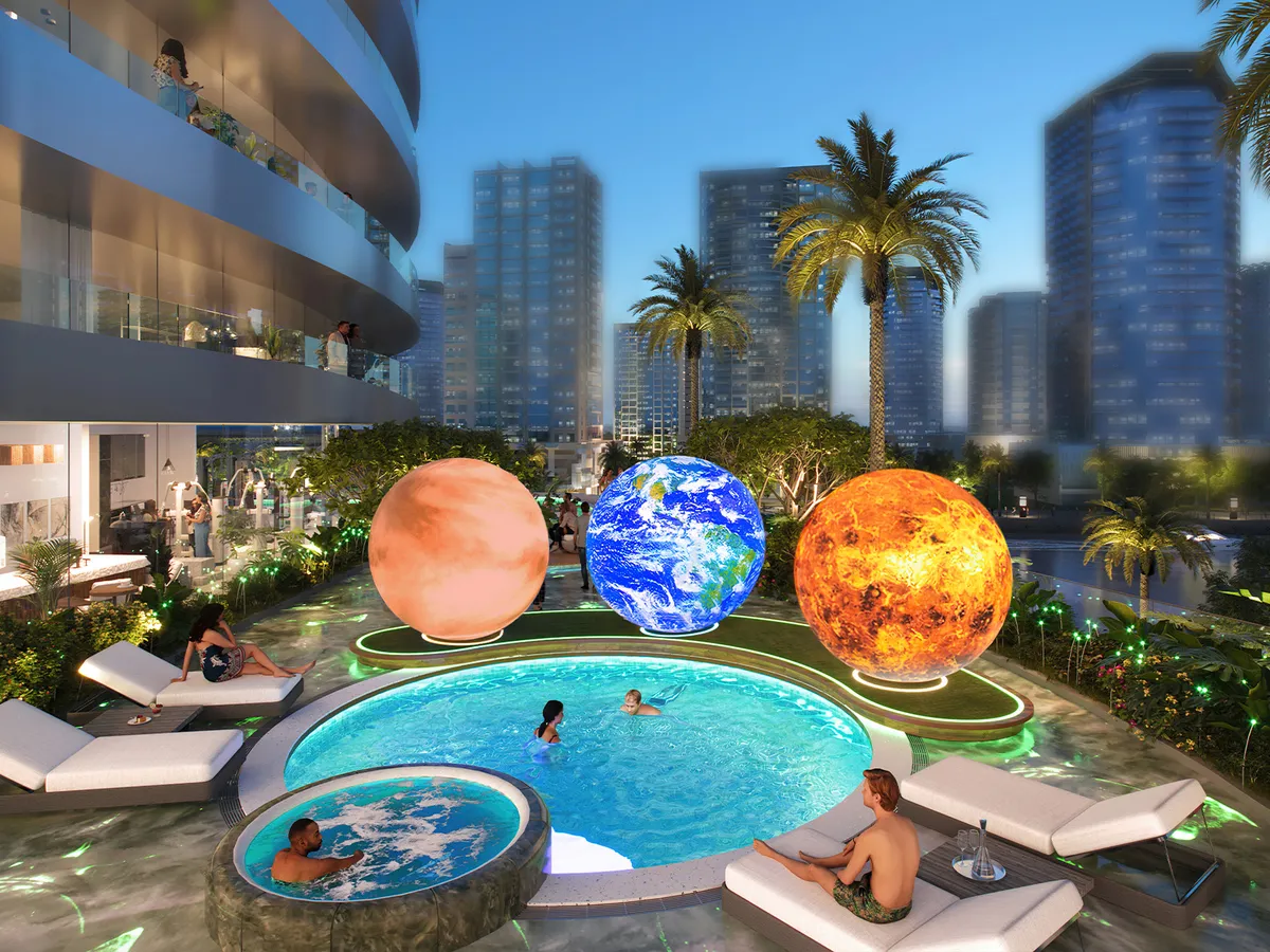 Pool at Canal Crown with illuminated planet sculptures and the Business Bay skyline behind