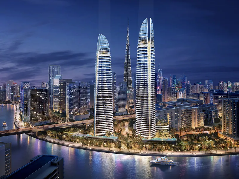 Night render of the two sail-shaped Canal Heights de GRISOGONO towers by DAMAC beside the Dubai Canal, with Burj Khalifa behind