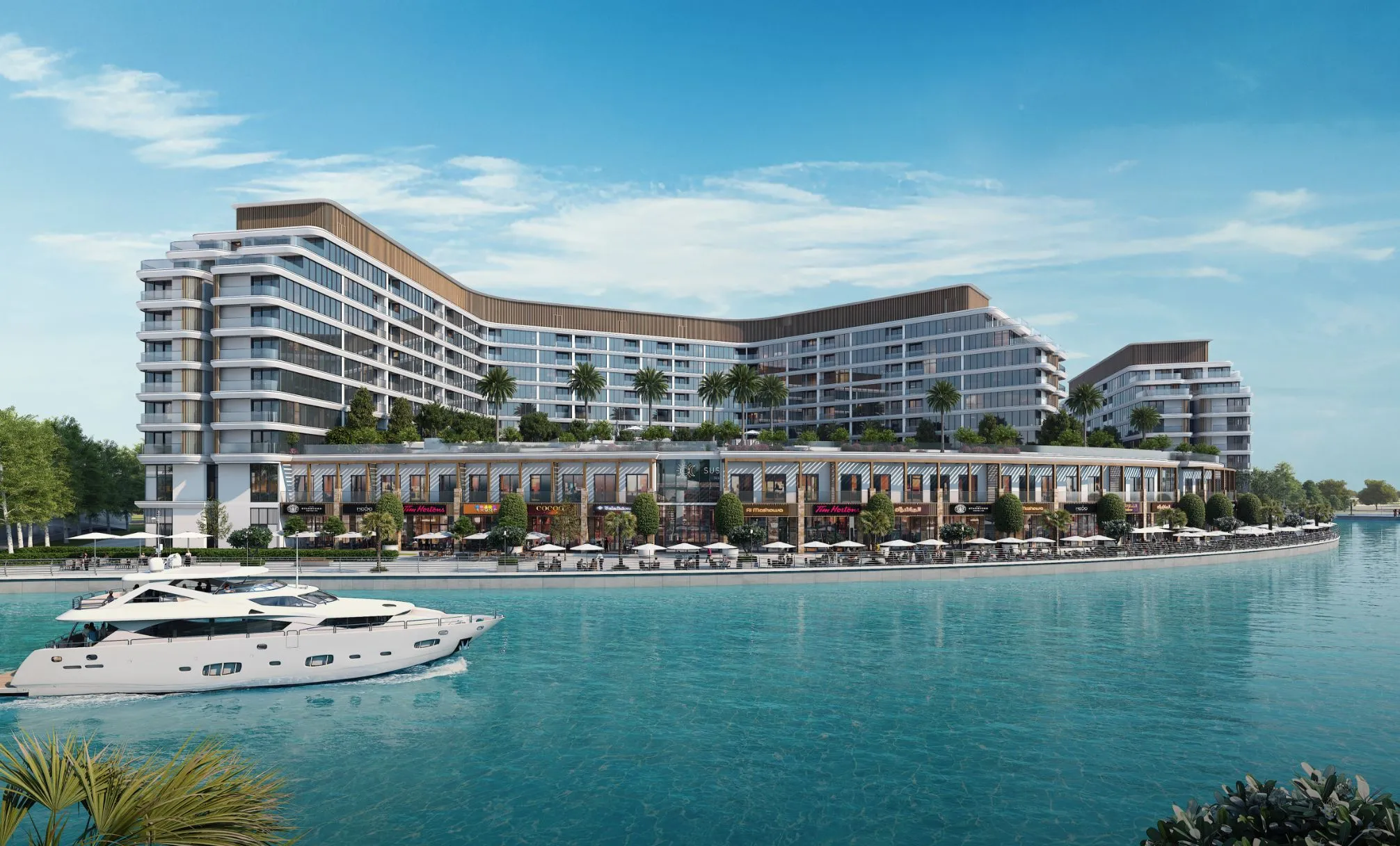 Canalside Marina Residences curving along the canal on Sobha Siniya Island, with a yacht passing in front