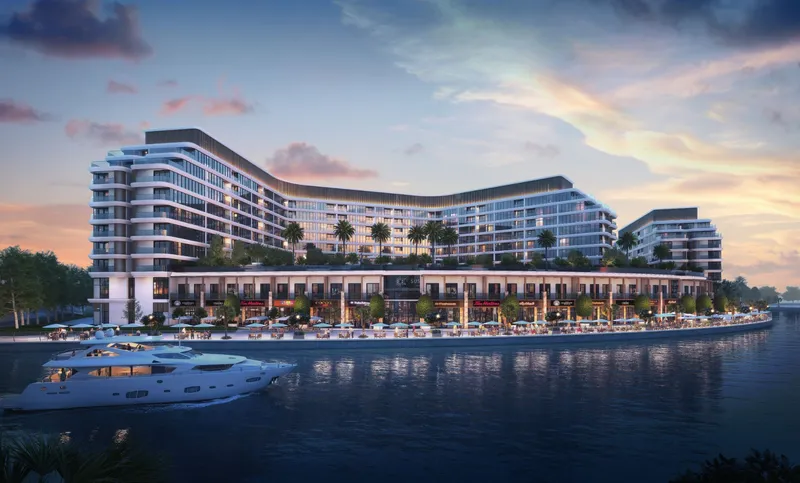 Canalside Marina Residences at dusk with the waterfront shops lit along the canal
