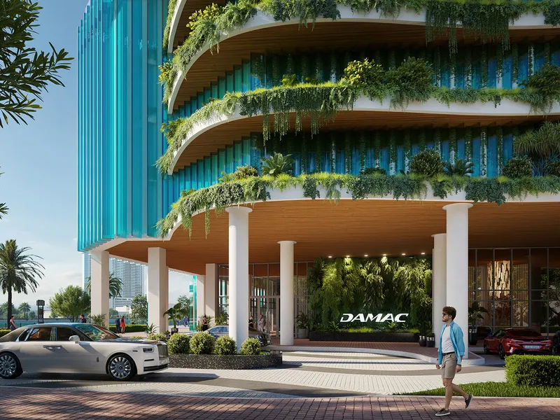 Street-level entrance of Chic Tower with white columns and planted balconies above