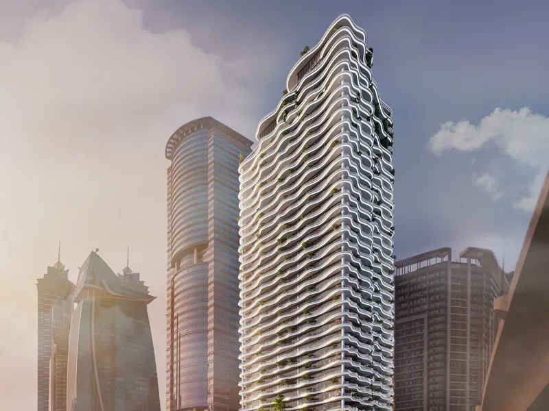 The white tower of Chic Tower with wave-shaped balconies rising among Business Bay high-rises