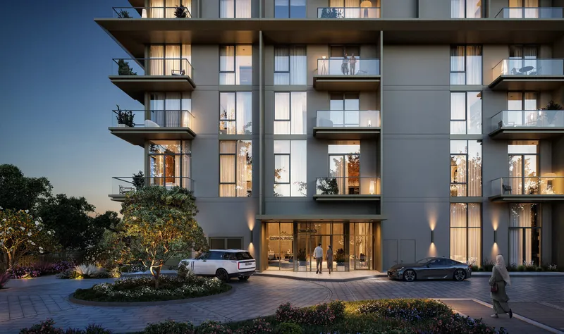 Render of the Club Place entrance and drop-off at dusk, with lit apartments and balconies above