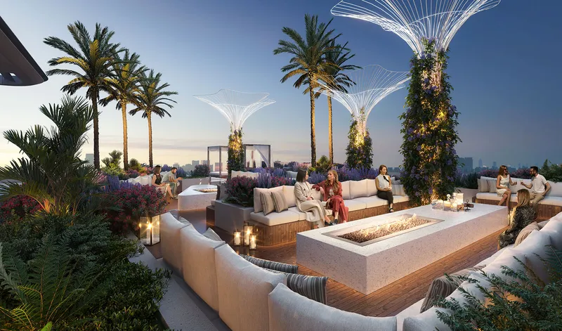 Outdoor fire pit lounge with sofas and palms at Cove by Imtiaz in the evening