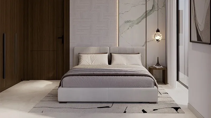 Bedroom with a marble-effect feature wall and dark wood wardrobes in a Coventry 49 apartment