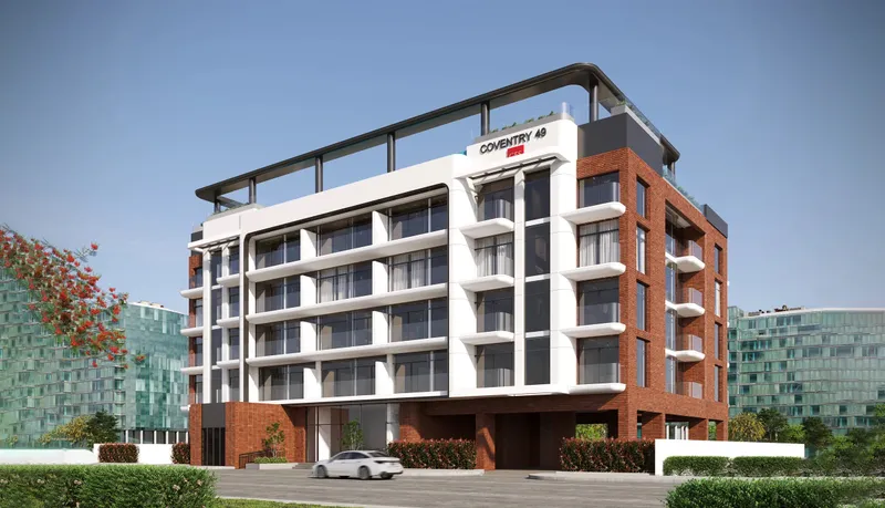 Coventry 49, a mid-rise apartment building with white balconies, red brick side walls and a rooftop deck