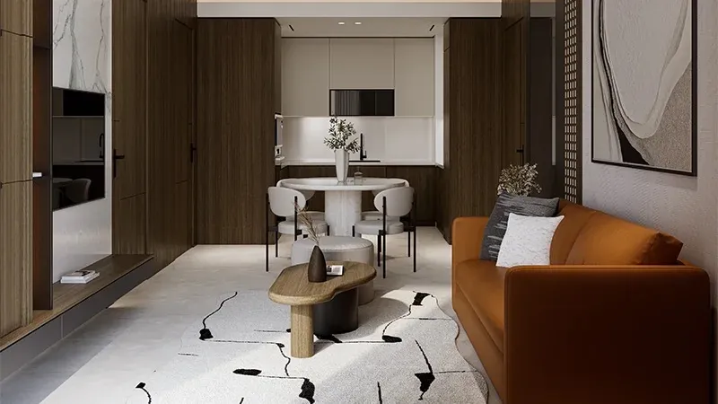 Living and dining room with an orange sofa, round dining table and fitted kitchen in a Coventry 49 apartment