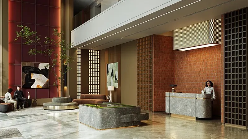 Double-height lobby with a stone reception desk, brick walls and lounge seating at Coventry 49