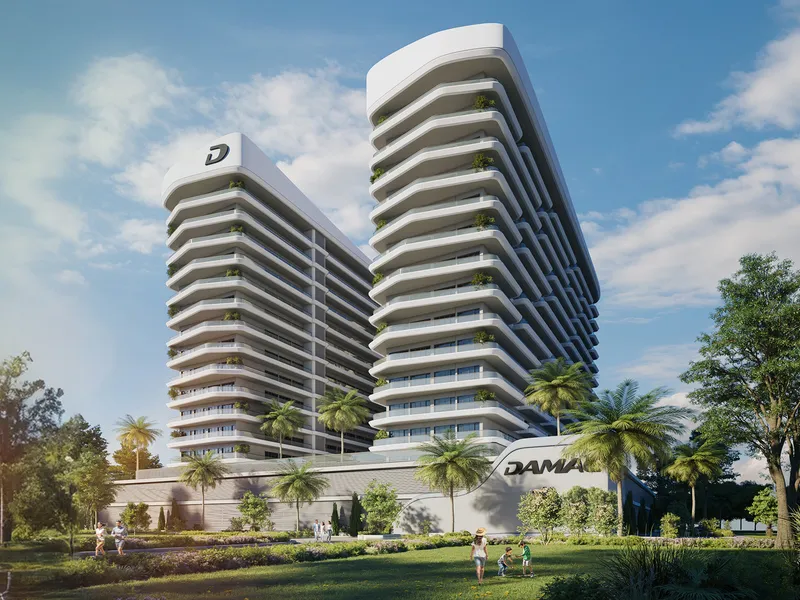 The curved white ELO tower with rows of balconies above a landscaped park in DAMAC Hills 2