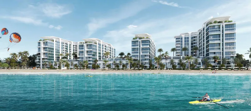 The four buildings of Florine Beach Residences seen from the water, with the beach in front
