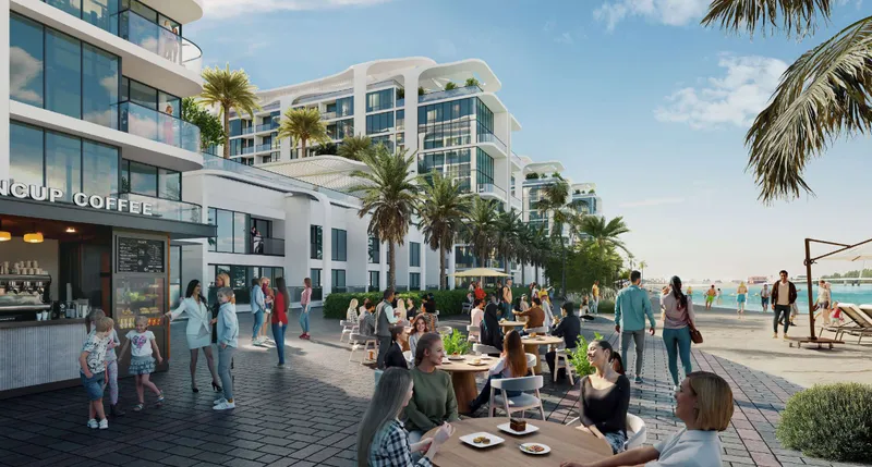 Café terrace on the beachfront street at Florine Beach Residences, with the buildings behind and the beach to one side