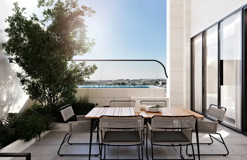 Outdoor dining table on a private terrace at Gharbi II with a view over Jumeirah Village Circle