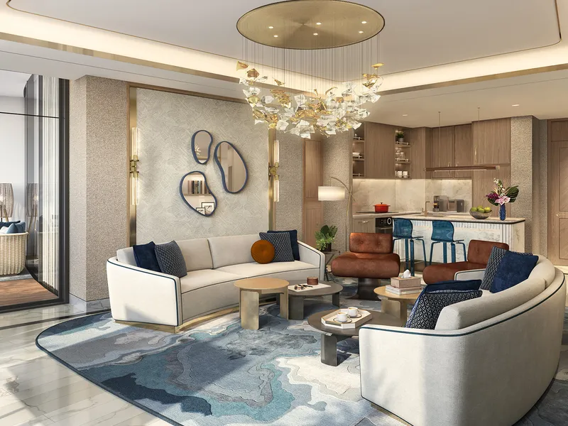 Living room and open kitchen at Harbour Lights with curved sofas and a gold chandelier