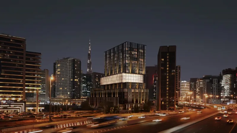 Night render of Haus of Tenet lit up beside a busy highway, with the Burj Khalifa in the distance