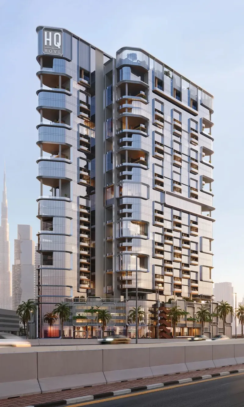 HQ by Rove office tower with curved balconies and the HQ by Rove sign at the top, beside a highway