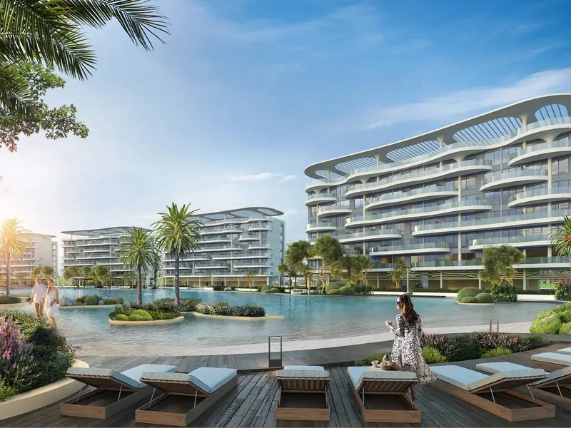 Lagoon Views apartment buildings with curved white balconies beside a lagoon and sun deck