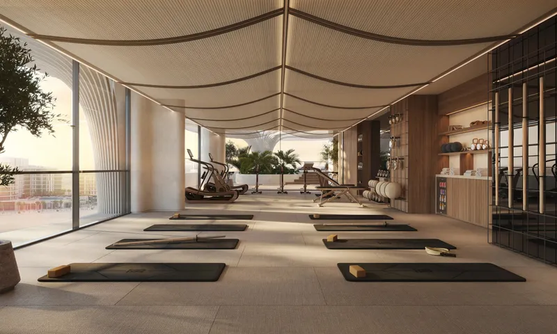 Render of the Mamsha Palm gym with yoga mats, exercise machines and floor-to-ceiling windows