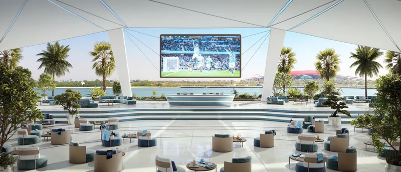 Covered terrace with lounge seating facing a large match screen and the canal