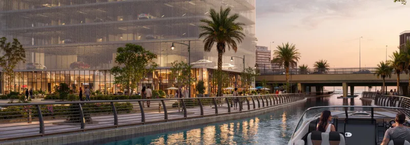 Canal promenade beside the Marlin Icon podium with ground-level retail and a boat on the water (developer render)