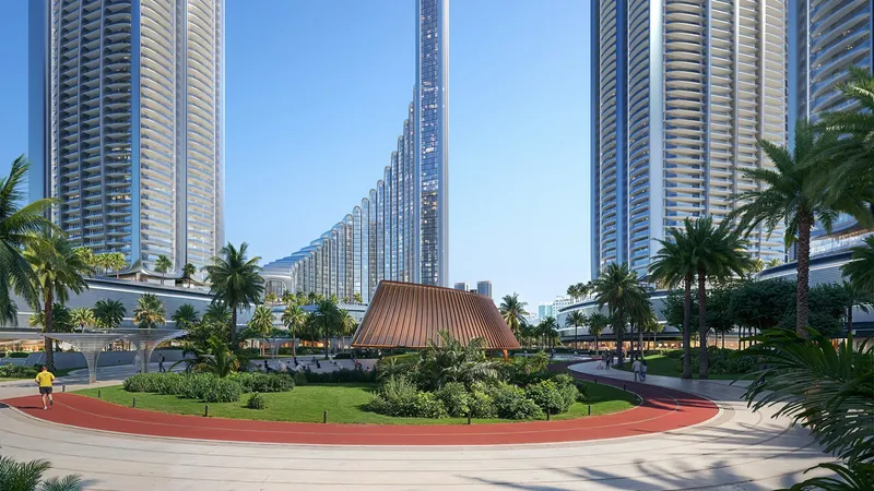 Running track, lawns and a pavilion in the Grand Promenade park, with the Binghatti City towers around it