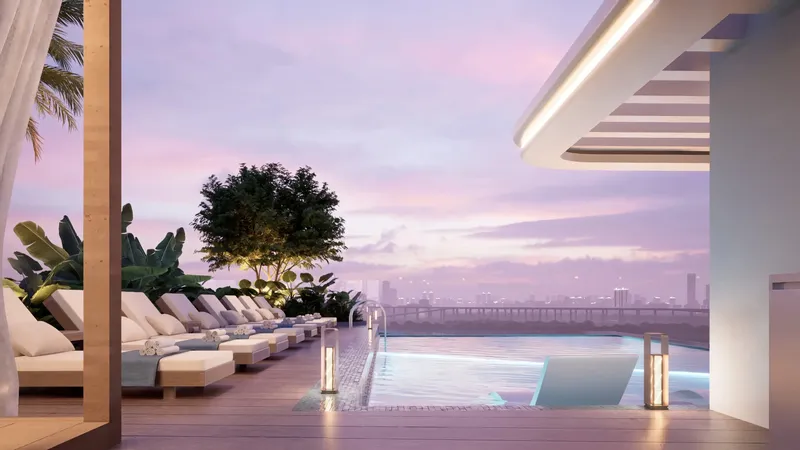 Rooftop infinity pool with a row of sunbeds at sunset at Meriden Beach Residences